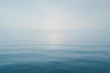Mirror-glass sea at morning with soft haze