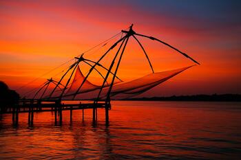 Chinese fishing nets at sunset with orange glow on water